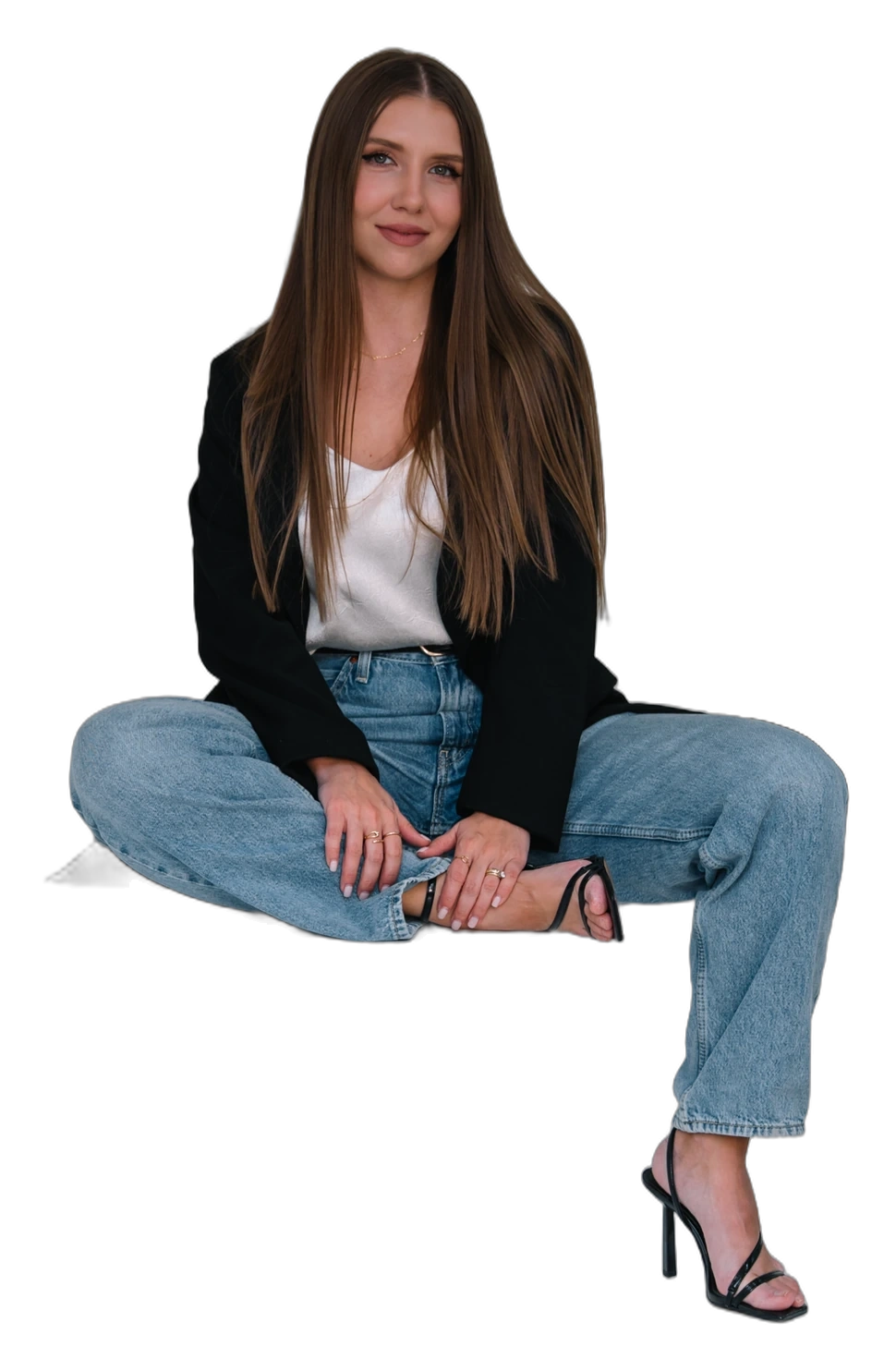 Alina Gobbi, founder of The Backstage Group, sitting in jeans and a black blazer